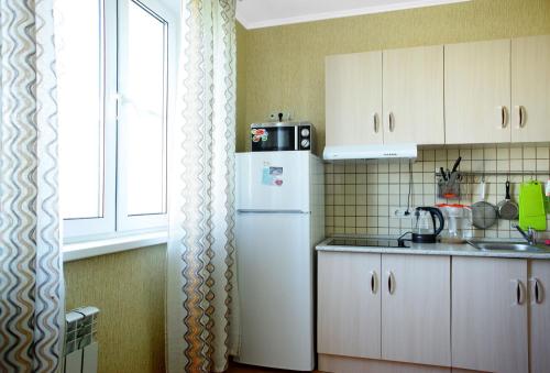 a kitchen with a white refrigerator and a window at Apartment at Osenniy Bulevard 7 in Moscow