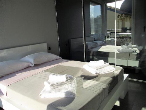 deux lits dans une chambre avec un miroir dans l'établissement Appartement Cattleya - rue halevy, à Nice