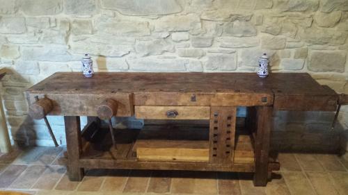 a wooden table in front of a stone wall at Valbuona b&b in Mercatello sul Metauro