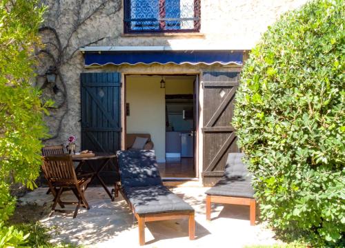 a patio with a table and chairs in front of a door at Domaine du Bois d'Amont in Cabris