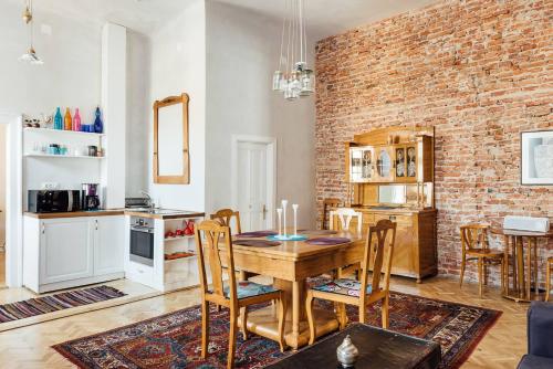 a dining room with a table and a brick wall at Cluj Apartments in Cluj-Napoca