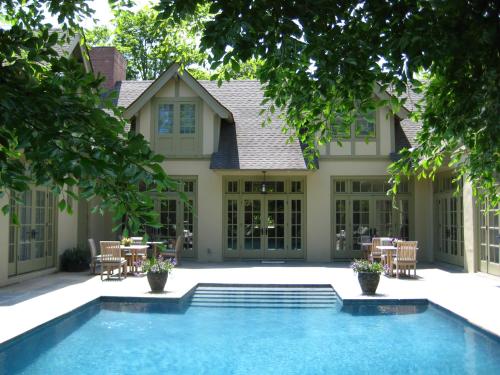 a swimming pool in front of a house at The Baker House 1650 in East Hampton