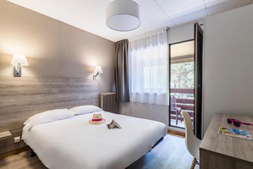 a hotel room with a large bed and a window at Azureva Cap d'Agde in Cap d'Agde