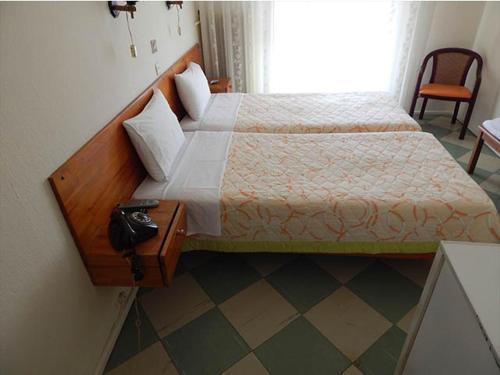 プリノスにあるLito Hotelのベッドルーム1室(ベッド1台、テーブル、窓付)