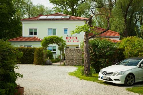 a white car parked in front of a house at Hotel Villa Rosa in Allershausen