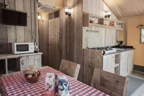 a kitchen with a table and a microwave at Camping Barco Reale in Lamporecchio