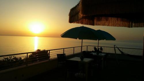 a sun setting over the ocean with an umbrella at B&B alla Canale in Vasto