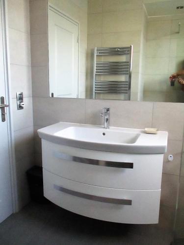 une salle de bain avec un lavabo blanc et un miroir dans l'établissement Appartement Cattleya - rue halevy, à Nice