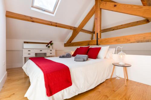 a bedroom with a large white bed with red pillows at Almada Studio 419 in Porto