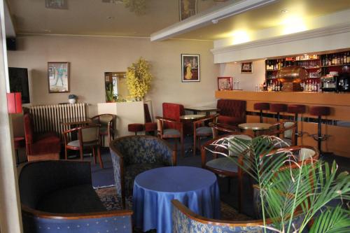 un restaurant avec des tables et des chaises et un bar dans l'établissement Le France, à Loudéac