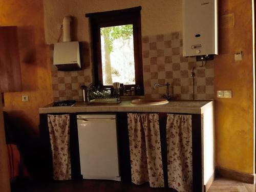 Valverde de la VeraにあるApartamentos Rurales Ecopangeaのキッチン(シンク付きカウンター、窓付)