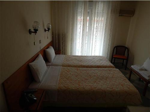 プリノスにあるLito Hotelのベッドと窓が備わるホテルルーム