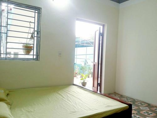 a bed in a room with an open window at Homestay Moc Chau in Mộc Châu