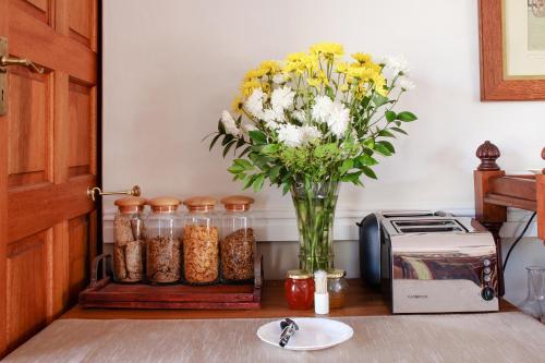 a vase of flowers on a table next to a toaster at AmaSun B&B in George