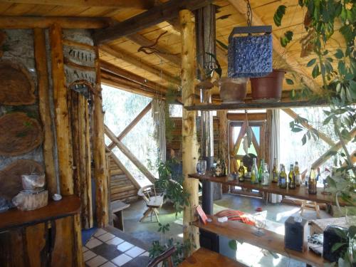 a room in a log cabin with a bunch of bottles at Cabanas Curi-Huapi in Isla Negra