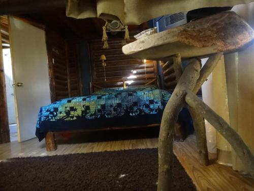 a bedroom with a bed with a blue blanket at Cabanas Curi-Huapi in Isla Negra