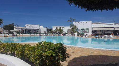 a large swimming pool in a resort with chairs at Marina Lucky in Playa Blanca