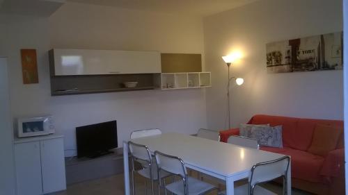 ein Wohnzimmer mit einem weißen Tisch und einem roten Sofa in der Unterkunft La Casetta di Marina di Massa in Marina di Massa