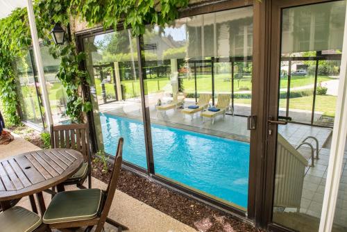 d'une terrasse avec une table et des chaises à côté de la piscine. dans l'établissement Château de Sancy, à Sancy-lès-Meaux