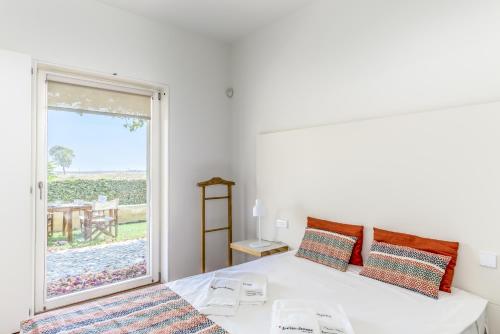1 dormitorio con cama y ventana grande en FLH Cozy Tavira with Pool, en Tavira