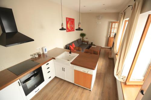 a kitchen with white cabinets and a living room at Casa Rural Miller's of Frigiliana in Frigiliana