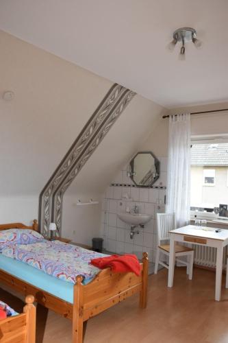 a bedroom with a bed and a sink at Pension Heister in Isselburg