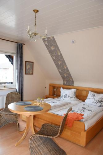 a bedroom with a bed and a table at Pension Heister in Isselburg