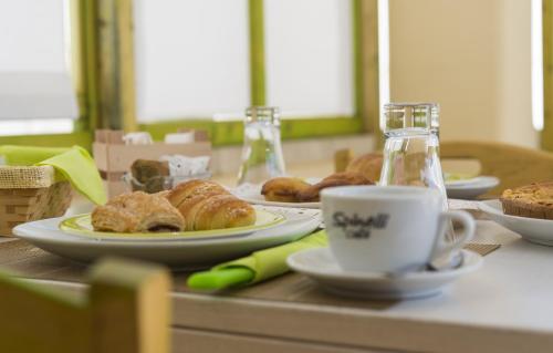 a table with plates of pastries and a cup of coffee at Notos b&b in Otranto