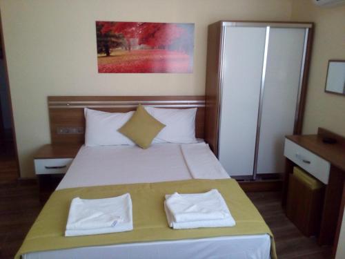 a bedroom with a bed with two white towels on it at Olimpiyat Hotel Izmir in Izmir