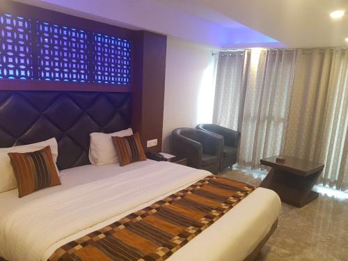 a hotel room with a bed and a chair at Hotel Hamers International in Mussoorie
