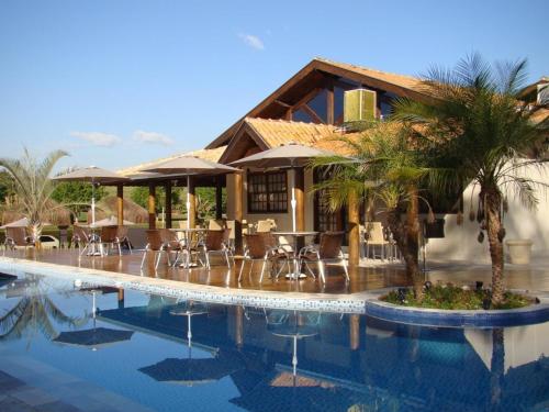 um resort com uma piscina com cadeiras e um edifício em Pissoloto Hotel em Sertanópolis