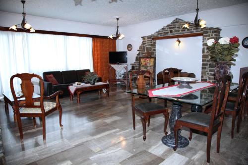 a living room with a table and chairs at Nikolas Hotel in Parikia