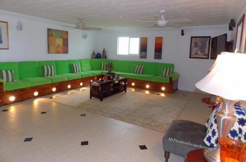 a living room with green couches and a table at Royal Vista Villa in Duncans