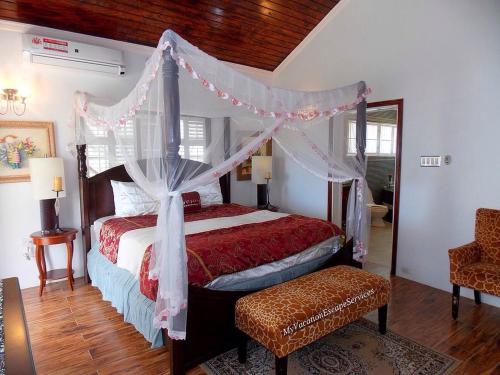 a bedroom with a bed with a canopy at Royal Vista Villa in Duncans