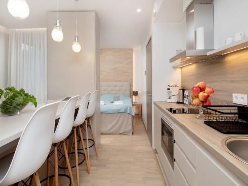 a kitchen with white counters and white stools at 8ERA Business Executive Rotermanni Apartments in Tallinn