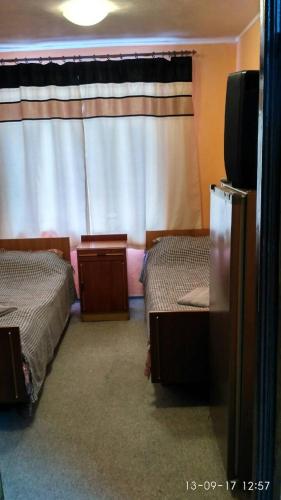 a room with two beds and a television in it at Hotel Europlus in Poltava