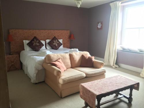 Heronshaw House في Hurn: غرفة نوم بسرير واريكة وطاولة