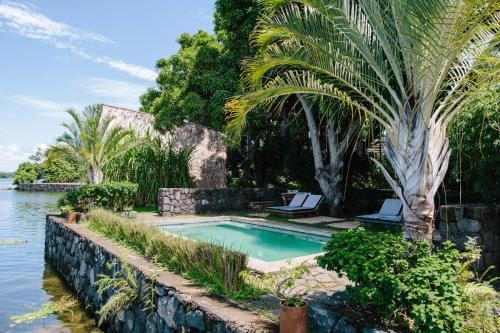 uma piscina com duas espreguiçadeiras junto à água em Isleta El Espino em Isletas de Granada