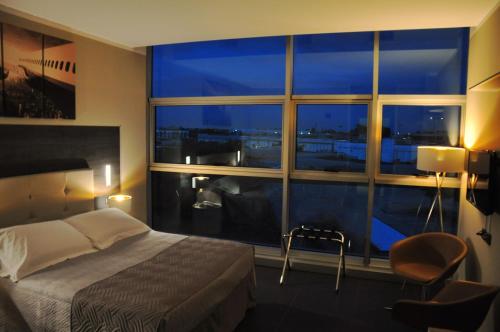 Star Hotel Airport Verona في دوسّوبونو: غرفة نوم بسرير ونافذة كبيرة