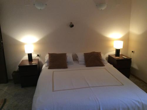 Razvalini Balchikioy的住宿－Villa Tunley，一间卧室配有一张带两盏灯的大型白色床。