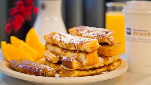 a plate of french toast with powdered sugar on top at Best Western West Towne Suites in Madison