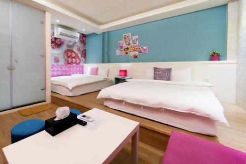 a room with two beds and a table at Steel and screws in Luodong