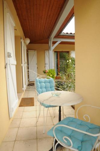 un patio avec une table et des chaises sur un porche dans l'établissement Les Pigeonnes, à Groléjac