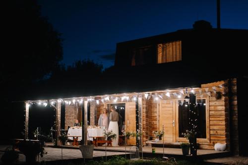 a bride and groom standing in the doorway of a house with lights at Annes in Pāce