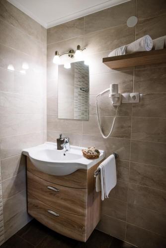 a bathroom with a sink and a mirror at Belvárosi Nemes Apartmanház Szekszárd in Szekszárd