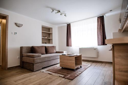 a living room with a couch and a table at Belvárosi Nemes Apartmanház Szekszárd in Szekszárd