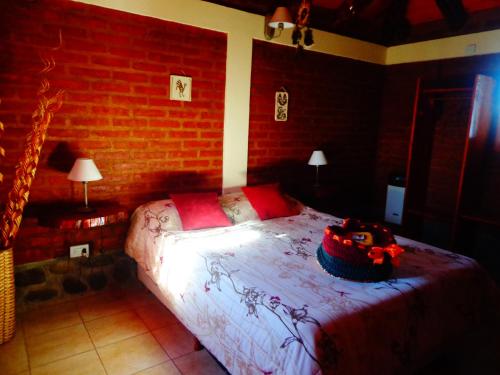 1 dormitorio con 1 cama grande en una pared de ladrillo en Cabañas Atrapasueños en Trevelín