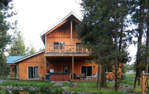 a log cabin with a porch and a balcony at DiamondStone Guest Lodges in La Pine