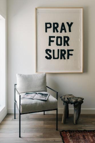 a living room with a bench and a sign for a pray for stuff at The Surfrider Malibu in Malibu