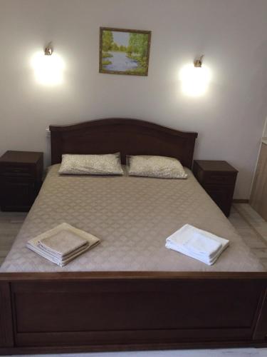 a bed with two pillows and two towels on it at Polyana Apart in Polyana
